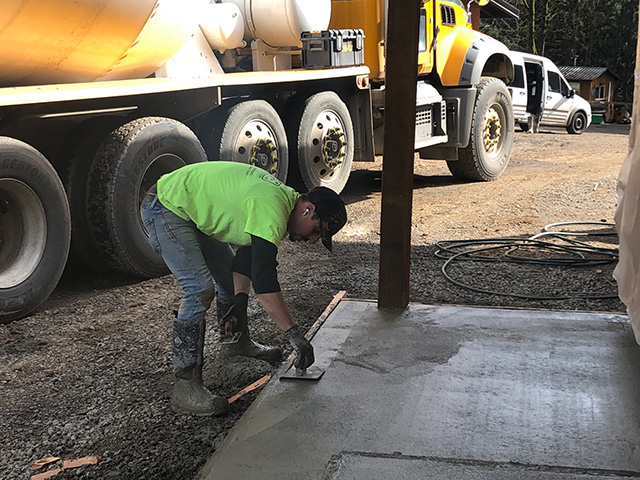 concrete pad being leveled by a construction worker